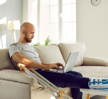 injury victim using laptop on sofa
